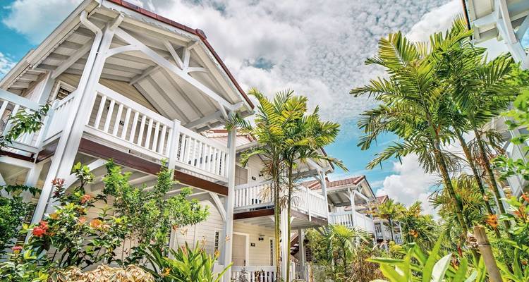 Tropisches Resort mit weißen Gebäuden und üppigem Grün.