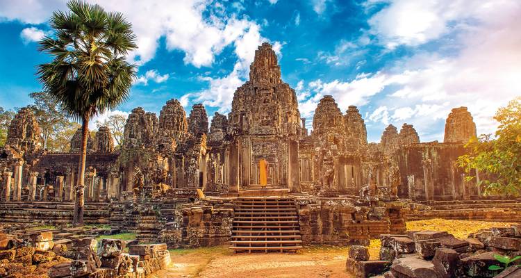 Magnifique temple de pierre antique avec des sculptures complexes et un visiteur solitaire au coucher du soleil.