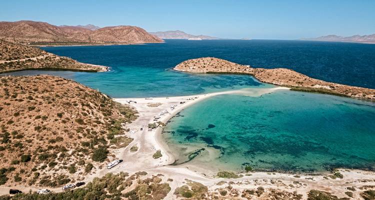 Aerial view of a coastal landscape with sandy beaches and clear blue water.
