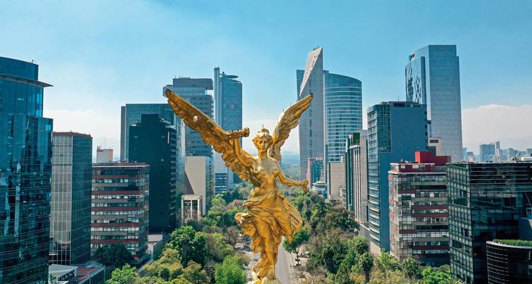 Vue de la ville avec une statue d'ange doré et des gratte-ciel.