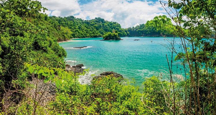 A beautiful coastal view with turquoise water and lush greenery.