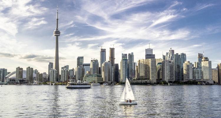 City skyline with a prominent tower seen from a lake.