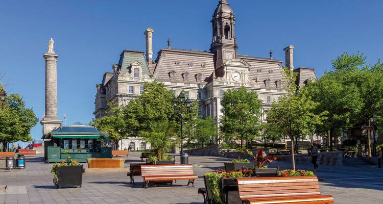 Bâtiments historiques et place avec arbres et bancs.