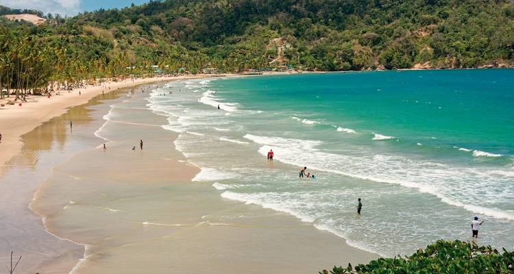Schilderachtig uitzicht op een tropisch strand met mensen die genieten van het water.