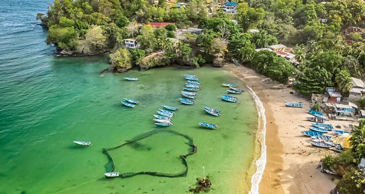 Luchtfoto van een kustdorp met boten die voor anker liggen in de zee.