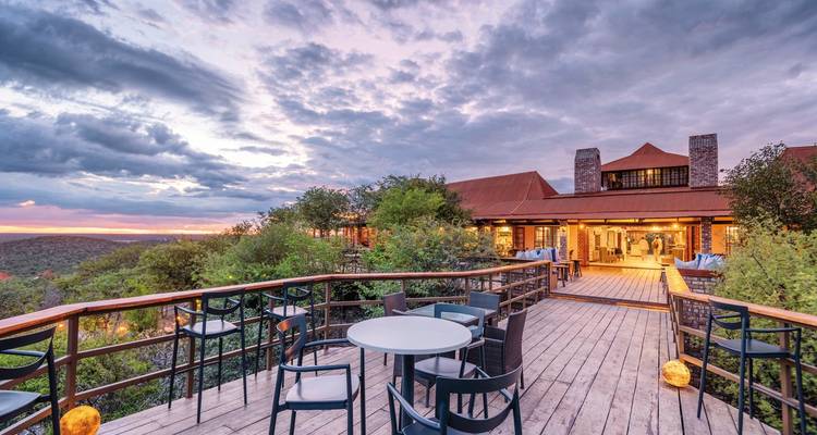 Hotel exterior with a large deck and sunset sky.