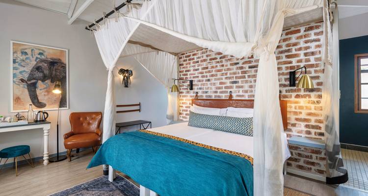 Stylish hotel room with bed and elephant themed decor.