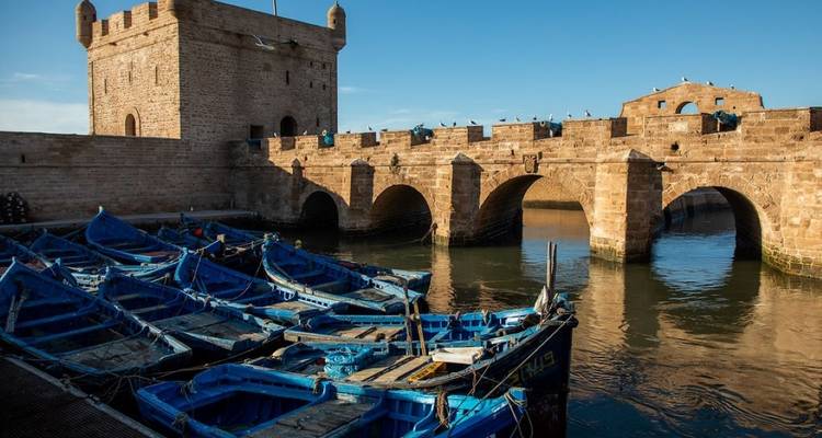 Hafen von Essaouira mit blauen Fischerbooten und Befestigungsanlagen.