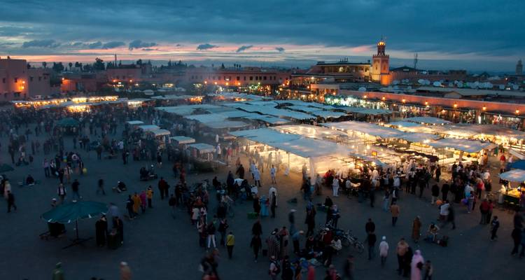 Market square bustling with people at dusk.