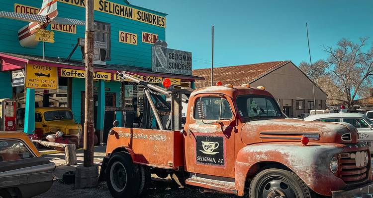 Devanture vintage de la Route 66 avec une façade turquoise éclatante et un vieux camion de dépannage rouillé garé à l'extérieur à Seligman, en Arizona.