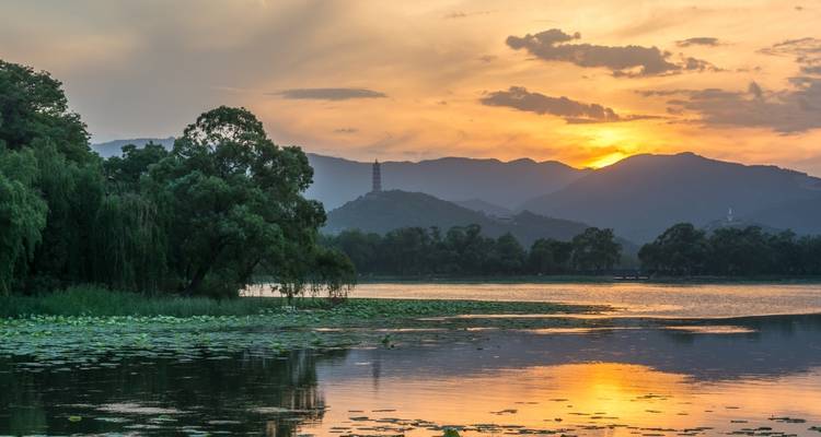 Sunset over a lake with mountains in the distance.