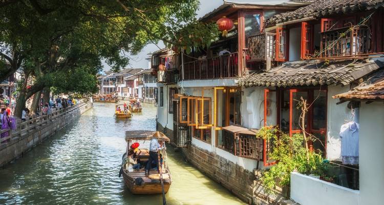 Canal tradicional con botes y edificios colgantes.