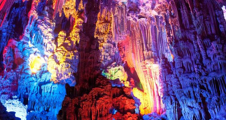 Colorful formations of stalactites and stalagmites in a cave.