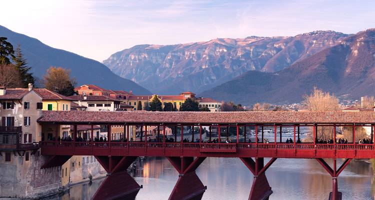 Historische overdekte houten brug Ponte degli Alpini over de rivier de Brenta met Alpisch achtergrond.