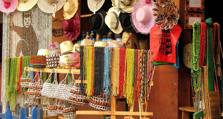 Colorful market stall displaying hats, beads, and other goods.
