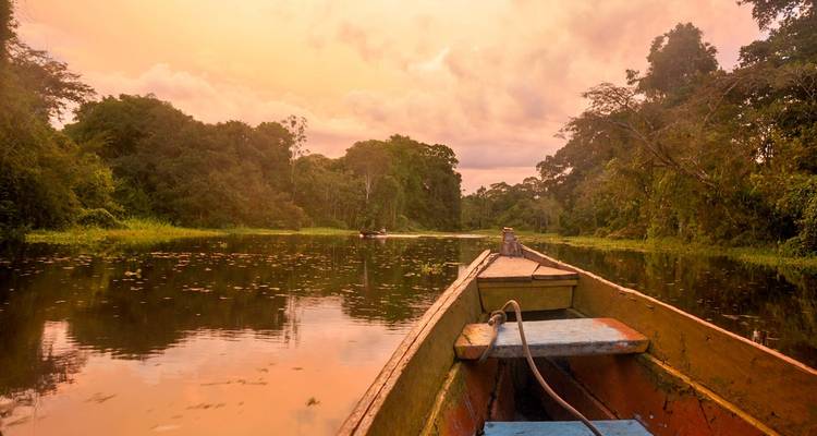 Ein malerischer Flussblick mit einem Boot bei Sonnenuntergang.