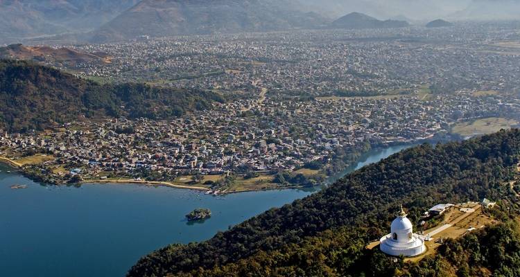 Vue aérienne d'une ville avec un grand lac bleu and une pagode blanche.