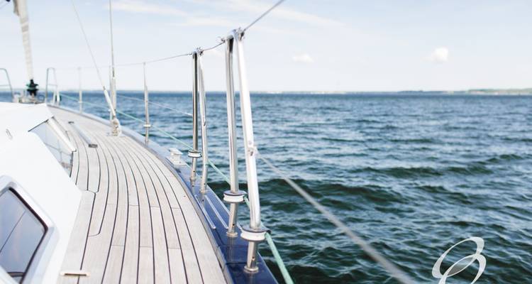 Een zicht van opzij van een jacht dat op de open zee vaart.