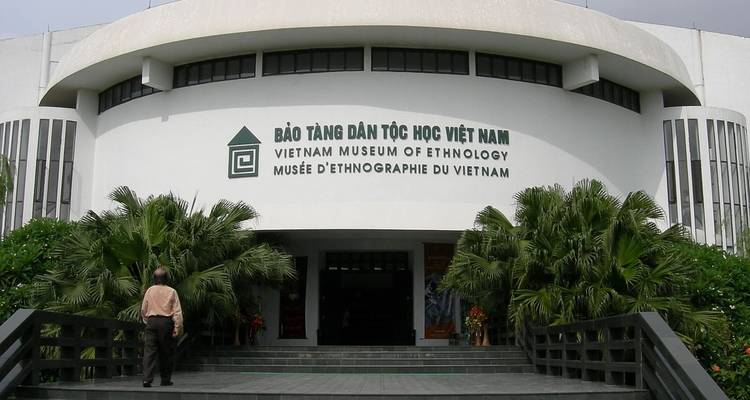 Entrance of a modern museum surrounded by greenery.