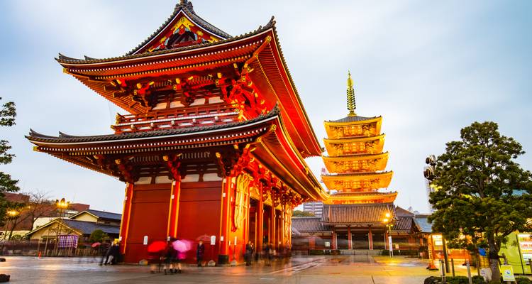 Temple vivement éclairé avec une pagode en arrière-plan.