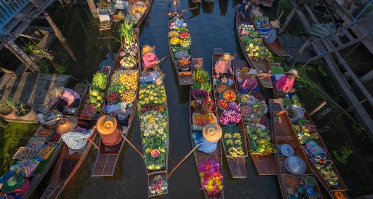 Des gens dans des bateaux vendant et achetant des marchandises dans un marché flottant.
