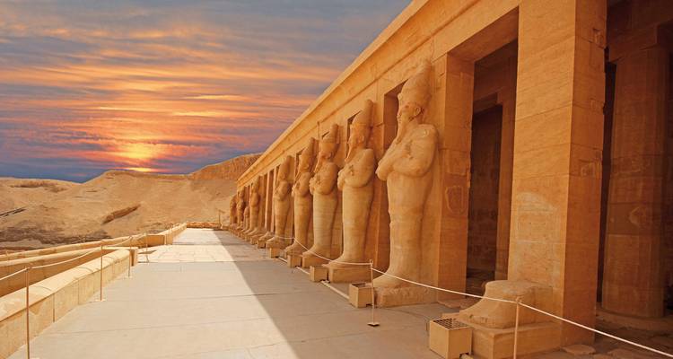 Säulenhalle des Tempels mit großartigen Statuen bei Sonnenuntergang.