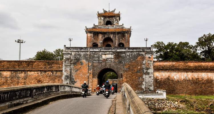 Porte historique avec des motos passant en dessous.