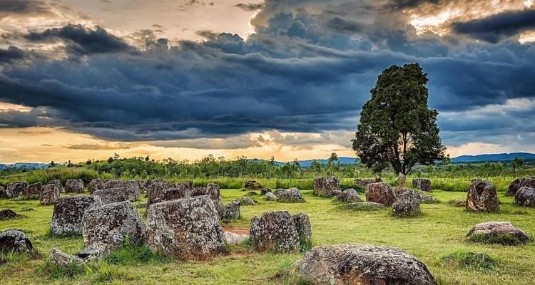 Paysage énigmatique de la Plaine des Jarres sous un ciel crépusculaire dramatique et nuageux