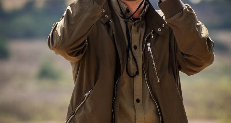 Persoon die een verrekijker gebruikt in een safari-omgeving.