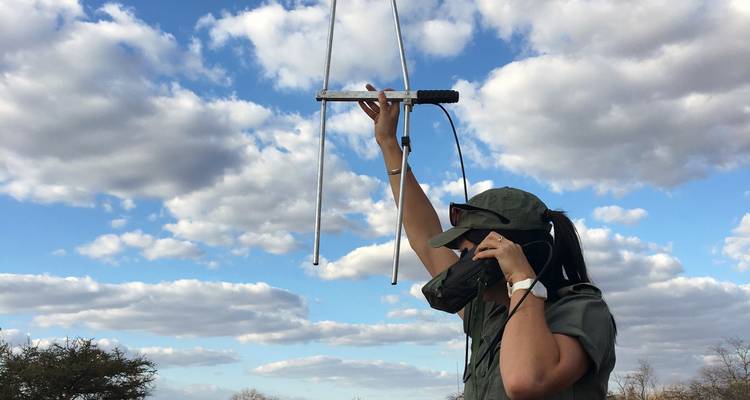 Persoon die een telemetrieapparaat vasthoudt tegen een blauwe lucht.
