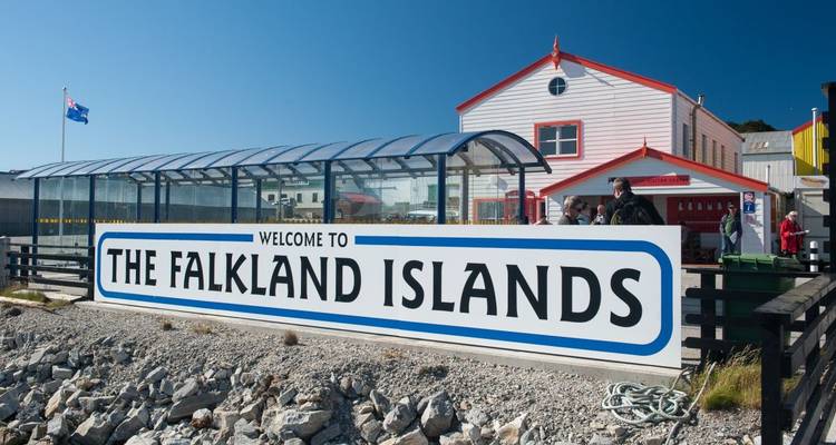 Falkland Islands sign with people and a building.