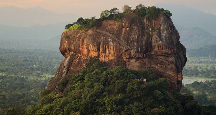 Close-up van Sigiriya rotsfort die hoog uittorent boven het weelderige woud in het zachte avondlicht.