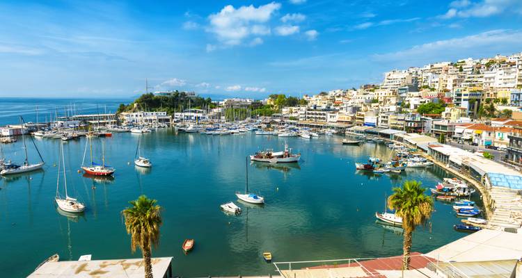 Vista del puerto con barcos amarrados y pueblo costero.