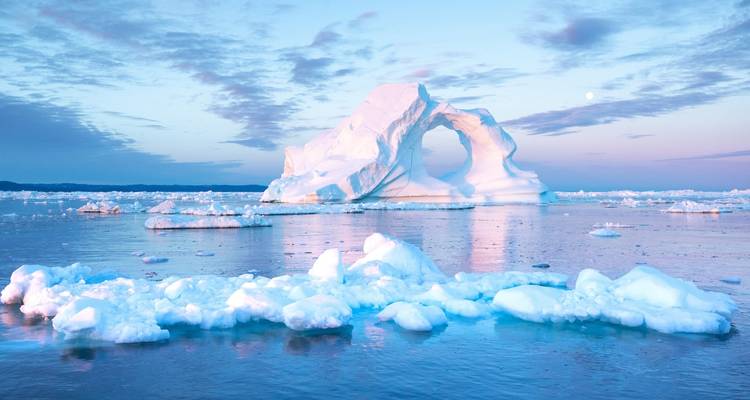 Impresionante formación de arco de iceberg en aguas heladas al atardecer.