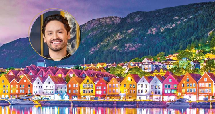 Vista nocturna de los coloridos edificios costeros de Bryggen con un retrato superpuesto en un círculo.