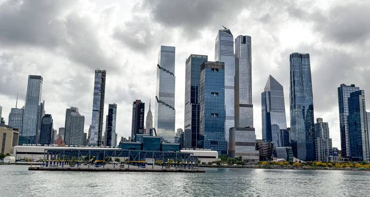 Paisaje urbano con modernos edificios de gran altura y cielo nublado.