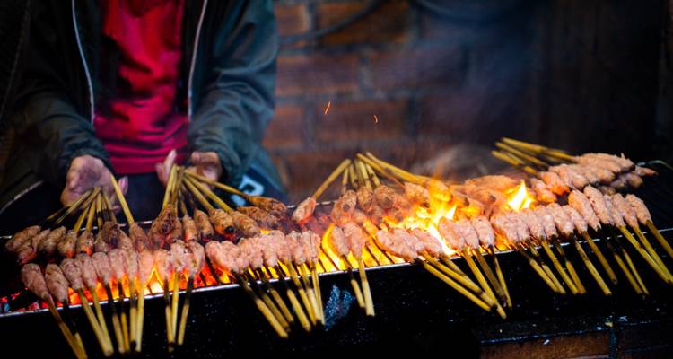 Grilled skewers of meat being cooked over an open flame.