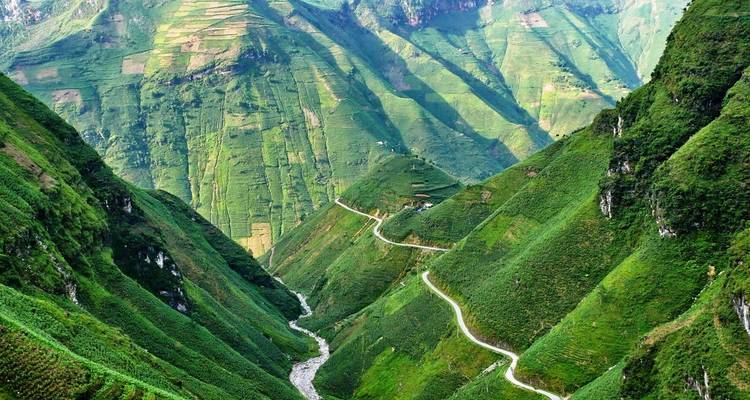 Een slingerende weg door groene bergen en dalen.