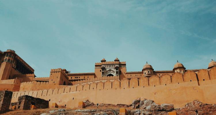 Een historisch fort met hoge muren onder een heldere blauwe lucht.