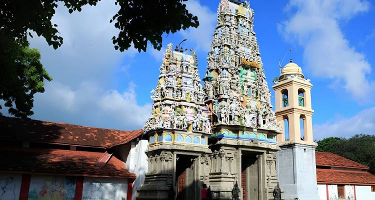 Ingewikkeld uitgesneden en fel beschilderde hindoetempel toren die tegen een blauwe lucht oprijst