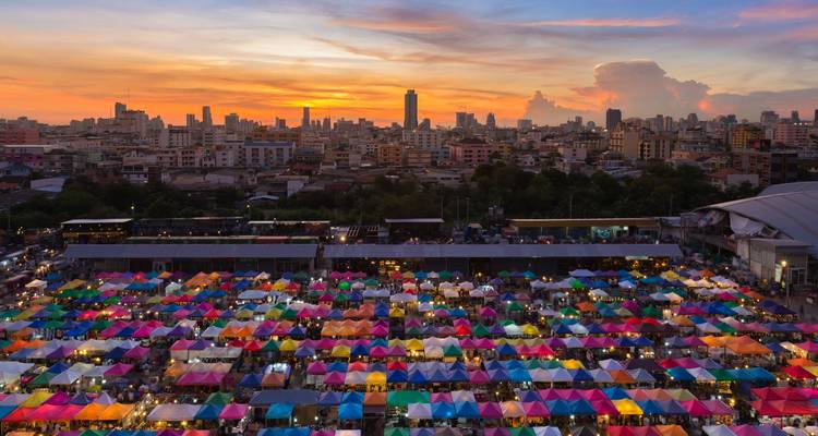 Mercado nocturno colorido con el horizonte de la ciudad al atardecer.