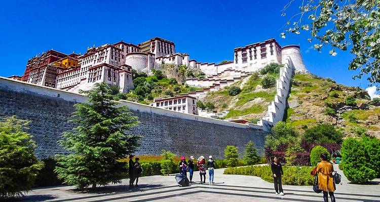 Touristen, die den Potala-Palast in Lhasa bei klarem blauen Himmel besuchen.