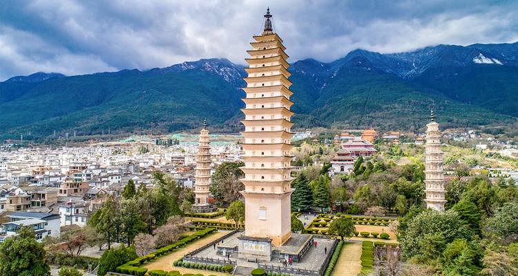 The central pagoda and two flank towers of Dali’s Three Pagodas rise above the old town with misty mountains behind.