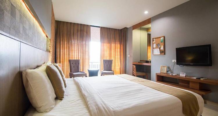 Gemütliches Hotelzimmer mit einem großen Fenster und einem Bett.