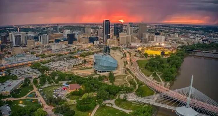 Vue aérienne au coucher du soleil de l'horizon de Winnipeg mettant en vedette le pont Esplanade Riel et le Musée canadien pour les droits de la personne.