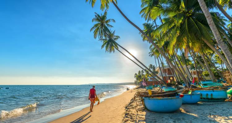Mensen die genieten van een zonnig strand met palmbomen.