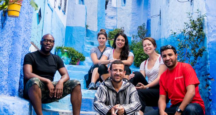 Des touristes posant sur un célèbre escalier peint en bleu.