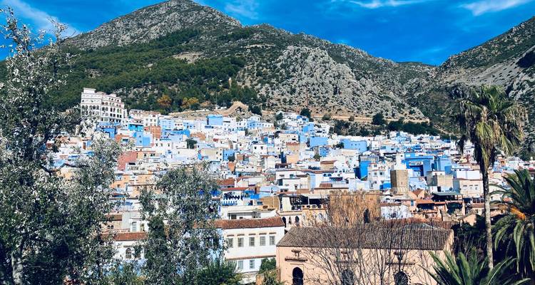 Malerische Aussicht auf eine Stadt mit blauen Gebäuden an einem Berghang.