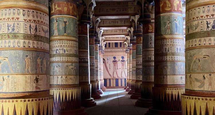 Innenraum eines kunstvoll verzierten Tempels mit farbenfrohen Säulen und Schnitzereien.