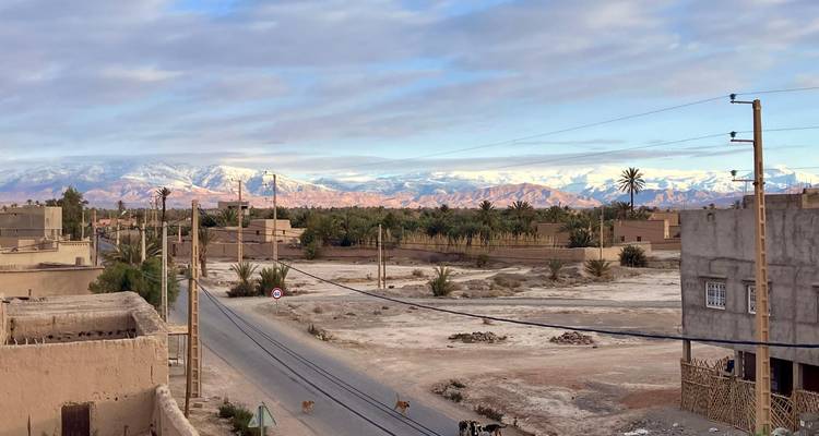 Eine ländliche Szene mit einer Straße, Häusern und Bergen in der Ferne.